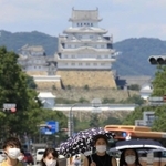 強い日差しが照りつける中、日傘を差して歩く女性ら＝１５日午後、姫路市駅前町（撮影・小林良多）