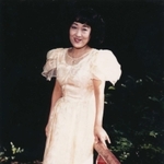 １９８０年代に自宅庭にある池の橋で写真に納まる山村美紗さん（京都新聞社提供）