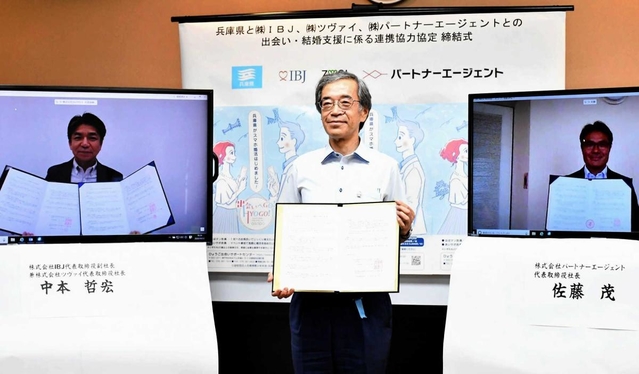婚活事業で連携する協定書を手にする金沢和夫副知事（中央）ら＝兵庫県庁