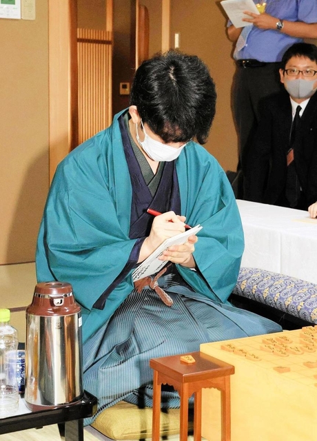 封じ手が入った封筒に署名する藤井聡太棋聖＝８月４日午後、神戸市北区有馬町、「中の坊瑞苑」
