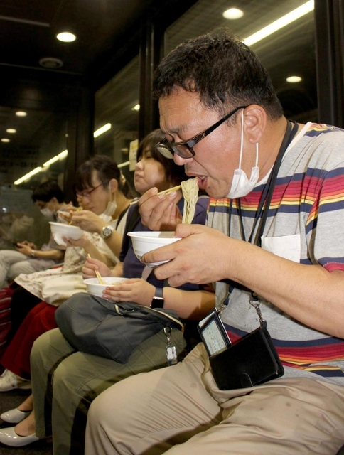 姫路駅名物「えきそば」をすする「銀河」の乗客＝１２日未明、ＪＲ姫路駅