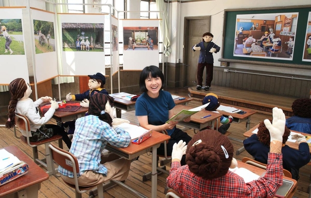 自称かかしフォトグラファーの臼井千夏さん。公募展会場に手作りのかかしと乗り込んだ＝京都市下京区、元淳風小学校