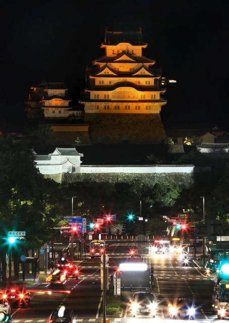 世界アルツハイマーデーに合わせ、オレンジ色に照らされた姫路城＝２１日夜、姫路市内