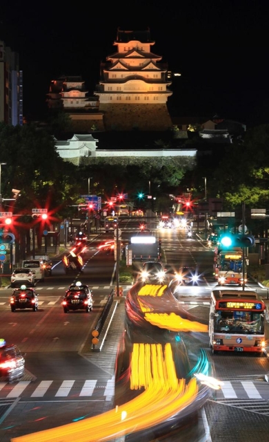 世界アルツハイマーデーに合わせ、オレンジ色に照らされた姫路城＝２１日夜、姫路市内