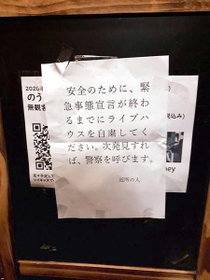４月、東京のダイニングバーの看板で見つかった休業を求める張り紙（提供写真）