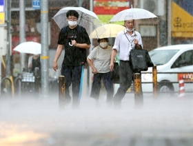 激しい雨で水しぶきが上がる歩道を、足早に歩く人たち＝２日午後２時６分、神戸市中央区相生町４（撮影・辰巳直之）