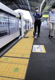 スマホでＱＲコードを読み取りながら歩く視覚障害者＝ＪＲ新神戸駅