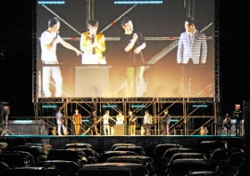 車内で芸人のトークを楽しむ「よしもとドライブインシアター」。駐車場からパッシングなどの反応で盛り上がった＝大阪府吹田市、万博記念公園
