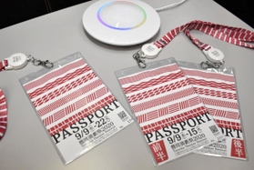 ブルートゥースの発信器が付いた特製パスポートと受信機＝豊岡市役所