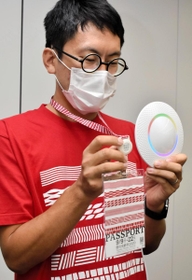 ブルートゥースの発信器が付いた特製パスポートと受信機＝豊岡市役所
