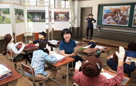 自称かかしフォトグラファーの臼井千夏さん。公募展会場に手作りのかかしと乗り込んだ＝京都市下京区、元淳風小学校