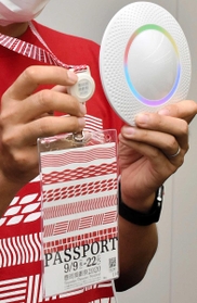 ブルートゥースの発信器が付いた特製パスポートと受信機＝豊岡市役所