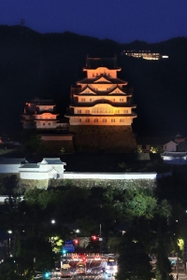 世界アルツハイマーデーに合わせ、オレンジ色に照らされた姫路城＝２１日夜、姫路市内