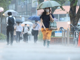 雨脚が強まる中、足元を気にしながら歩く人ら＝２５日午前、神戸市中央区相生町３