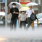 激しい雨で水しぶきが上がる歩道を、足早に歩く人たち＝２日午後２時６分、神戸市中央区相生町４（撮影・辰巳直之）