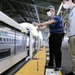 点字ブロック上のＱＲコードを読み取って駅構内を移動する視覚障害者＝ＪＲ新神戸駅