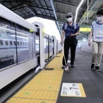 スマホでＱＲコードを読み取りながら歩く視覚障害者＝ＪＲ新神戸駅