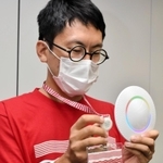 ブルートゥースの発信器が付いた特製パスポートと受信機＝豊岡市役所