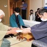 立会人の淡路仁茂九段に封じ手が入った封筒を渡す木村一基王位（右）＝８月４日午後、神戸市北区有馬町、「中の坊瑞苑」