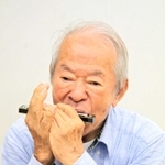 戦中に小学校の先生の家で教えてもらったハーモニカを吹く田間貞雄さん＝西宮市浜脇町、浜脇小学校