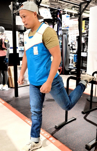 筋トレやストレッチなどに適した機器を実演するデカトロンの西山健史さん＝西宮市高松町