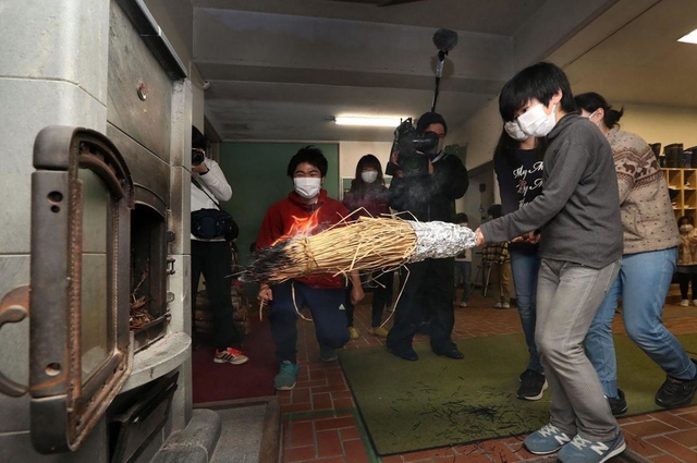 自分たちでおこした火をストーブに移す児童ら＝２３日午前、神戸市立六甲山小学校