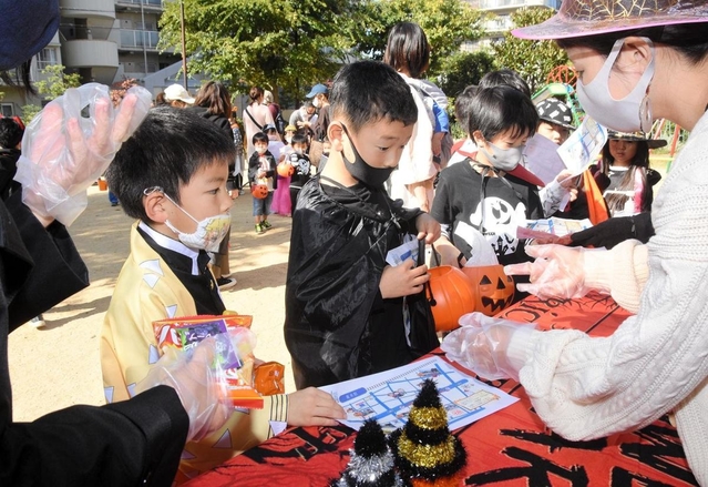 仮装姿でお菓子を受け取る子どもたち＝３１日午前、神戸市東灘区青木２