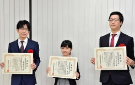 表彰状を手に笑顔で記念撮影に応じる（左から）豊島将之二冠、仲邑菫初段、村川大介九段＝関西将棋会館