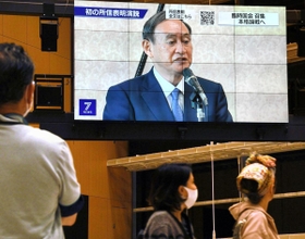 所信表明した菅義偉首相を報じるニュース画面。足を止めて見入る人もいた＝２６日夜、明石市大明石町１（撮影・後藤亮平）
