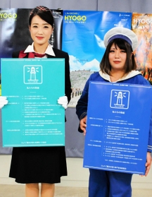 感染防止策のロゴマークを紹介するバスガイド（左）と観光船の船長＝兵庫県庁