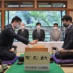 天元戦第１局で初手を打つ一力遼碁聖（左）と井山裕太天元＝８日午前、名古屋市、賀城園