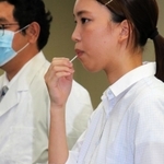 ＰＣＲ検査の唾液採取キットを試用する助手ら＝西宮市甲子園九番町、武庫川女子大