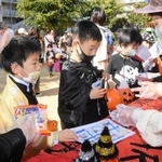 仮装姿でお菓子を受け取る子どもたち＝３１日午前、神戸市東灘区青木２