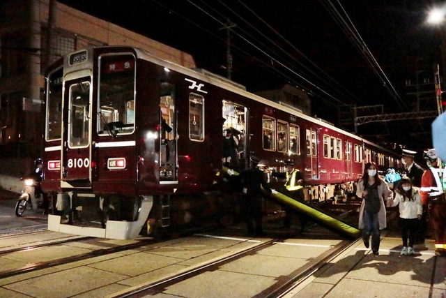 脱線した特急電車から座席（中央）を滑り台代わりにして脱出する乗客＝２３日午後８時２４分、神戸市灘区宮山町１（撮影・小谷千穂）