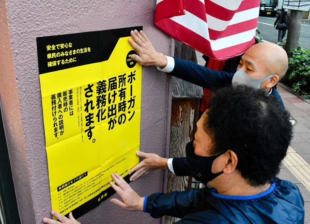 ボーガン販売店の店先に張られた新条例の啓発ポスター＝神戸市内