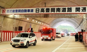 「日高豊岡南道路」が開通。トンネル内での式典後、関係車両がパレードして祝った＝豊岡市上佐野