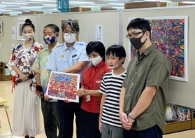自身の作品展会場を訪れ、来場者にあいさつした柳生千裕君（右から２人目）＝那覇市牧志１、ジュンク堂書店那覇店（柳生尚央さん提供）