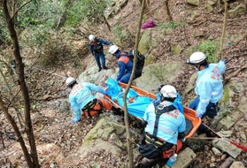 六甲山系の険しい斜面で、傷病者を搬送する神戸市消防局の救急隊員ら。今年は出動が増えている＝２０１９年４月、神戸市中央区（同消防局提供）
