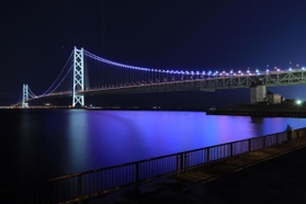 青い光で照らされた明石海峡大橋＝１３日夜、神戸市垂水区（撮影・吉田敦史）