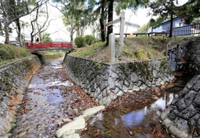 高谷川の境界部分。川の流れが分岐し、「日本海へ約７０キロ」「瀬戸内海へ約７０キロ」と書かれた看板が立つ＝丹波市氷上町石生