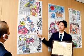 イラストを矢野交通部長（左）に説明する蓬莱大介さん＝兵庫県警