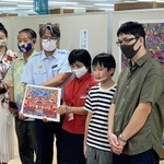自身の作品展会場を訪れ、来場者にあいさつした柳生千裕君（右から２人目）＝那覇市牧志１、ジュンク堂書店那覇店（柳生尚央さん提供）