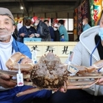 松葉ガニを１匹２５０万円で落札した男性（右）＝兵庫県新温泉町、浜坂漁港