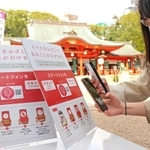 おみくじの番号が引けるＱＲコードなどにスマートフォンをかざす参拝客＝生田神社