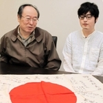 戦後７５年の節目に、姫路へ帰ってきた日章旗を見つめる岡本明さん（左）と四男崇宏さん＝姫路市本町