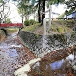 高谷川の境界部分。川の流れが分岐し、「日本海へ約７０キロ」「瀬戸内海へ約７０キロ」と書かれた看板が立つ＝丹波市氷上町石生
