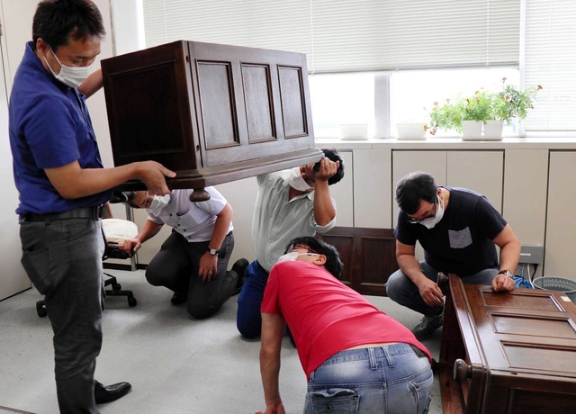 兵庫県庁の監査委員室で机を検分する神戸洋家具の若手経営者ら＝神戸市中央区下山手通５