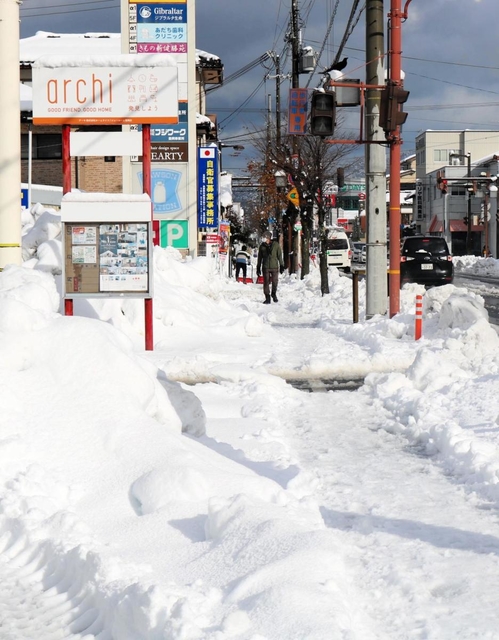 屋根や路面が雪に覆われた市街地＝１７日午前、豊岡市大手町（撮影・阿部江利）