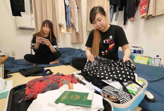 共同生活を送る部屋でいつでも帰国できるように荷物を整えていたグエン・ティ・モン・トゥエンさん（手前）＝９月３日、神戸市兵庫区