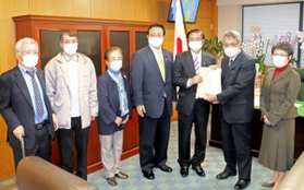 山本博司厚生労働副大臣（右から３人目）に要望書を手渡す支援団体関係者ら＝厚労省